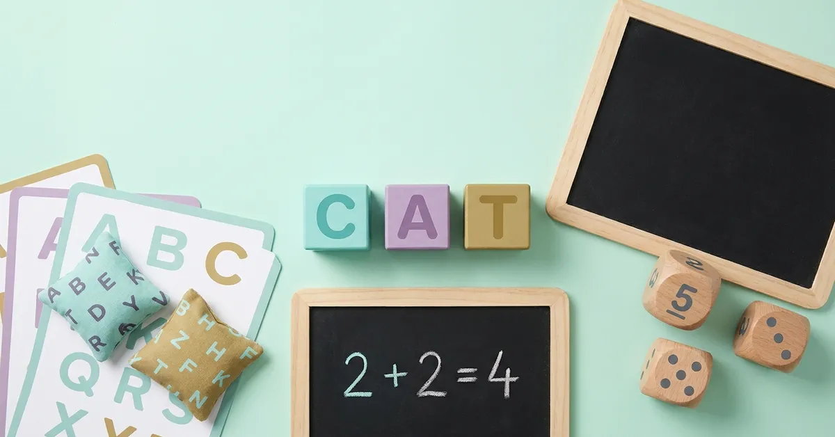 School skills made physical for ages 5 to 7: letter blocks spelling CAT, bean bags on letter cards and a small chalkboard.